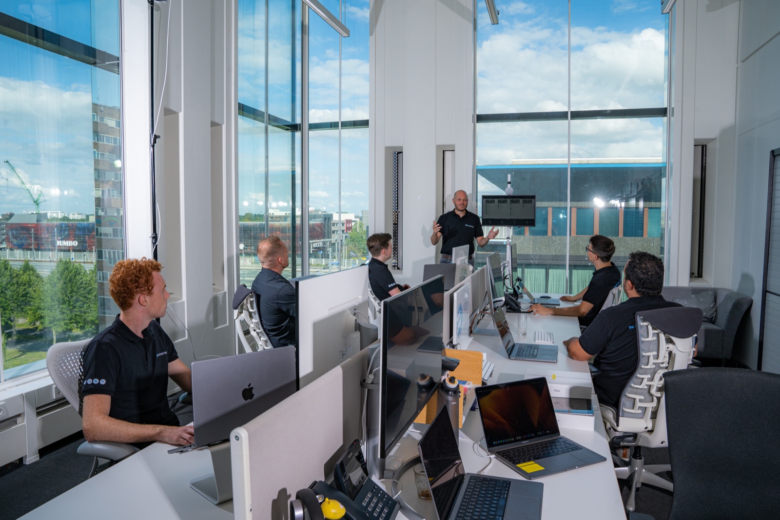 Cloudcarrier team aan het werk op iMacs in een moderne werkomgeving